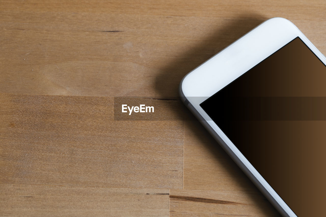 Close-up of mobile phone on wooden table