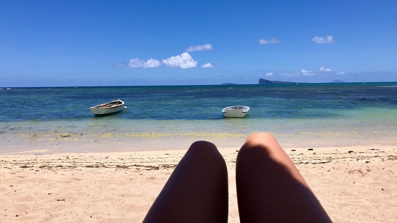 Cropped hand gesturing against at beach