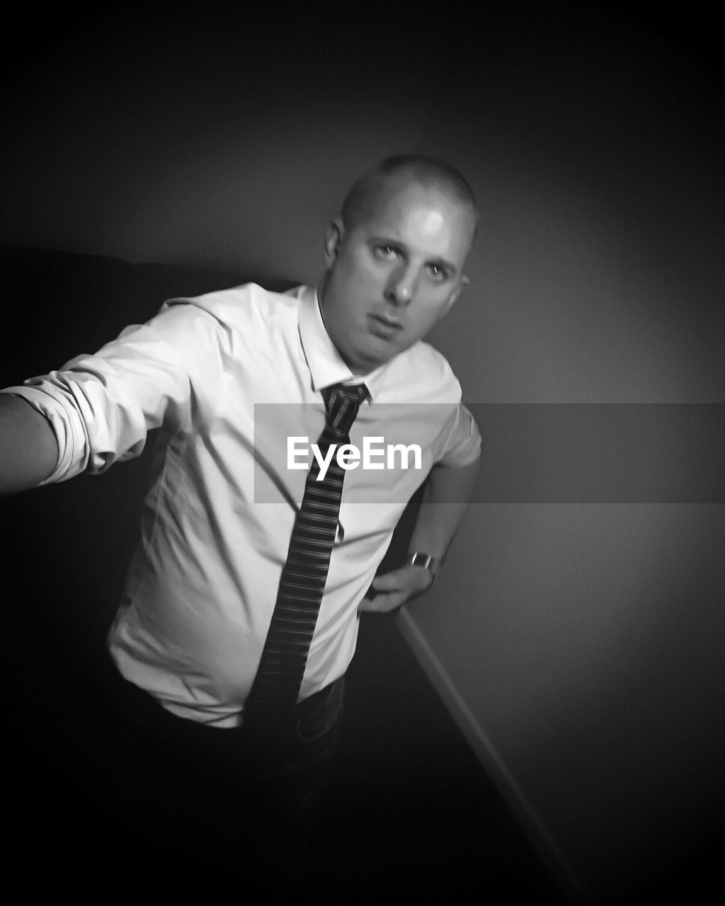 Portrait of man in shirt and tie by wall