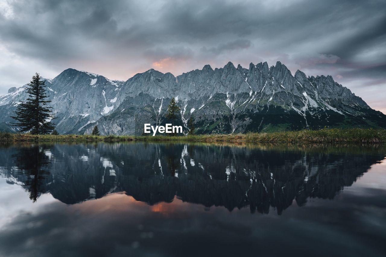 Scenic view of lake by mountains against sky