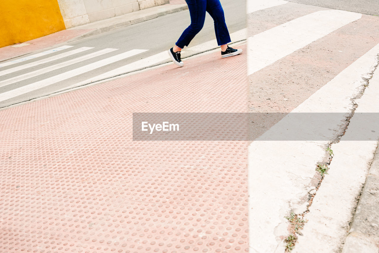 LOW SECTION OF MAN WALKING ON COBBLESTONE FOOTPATH