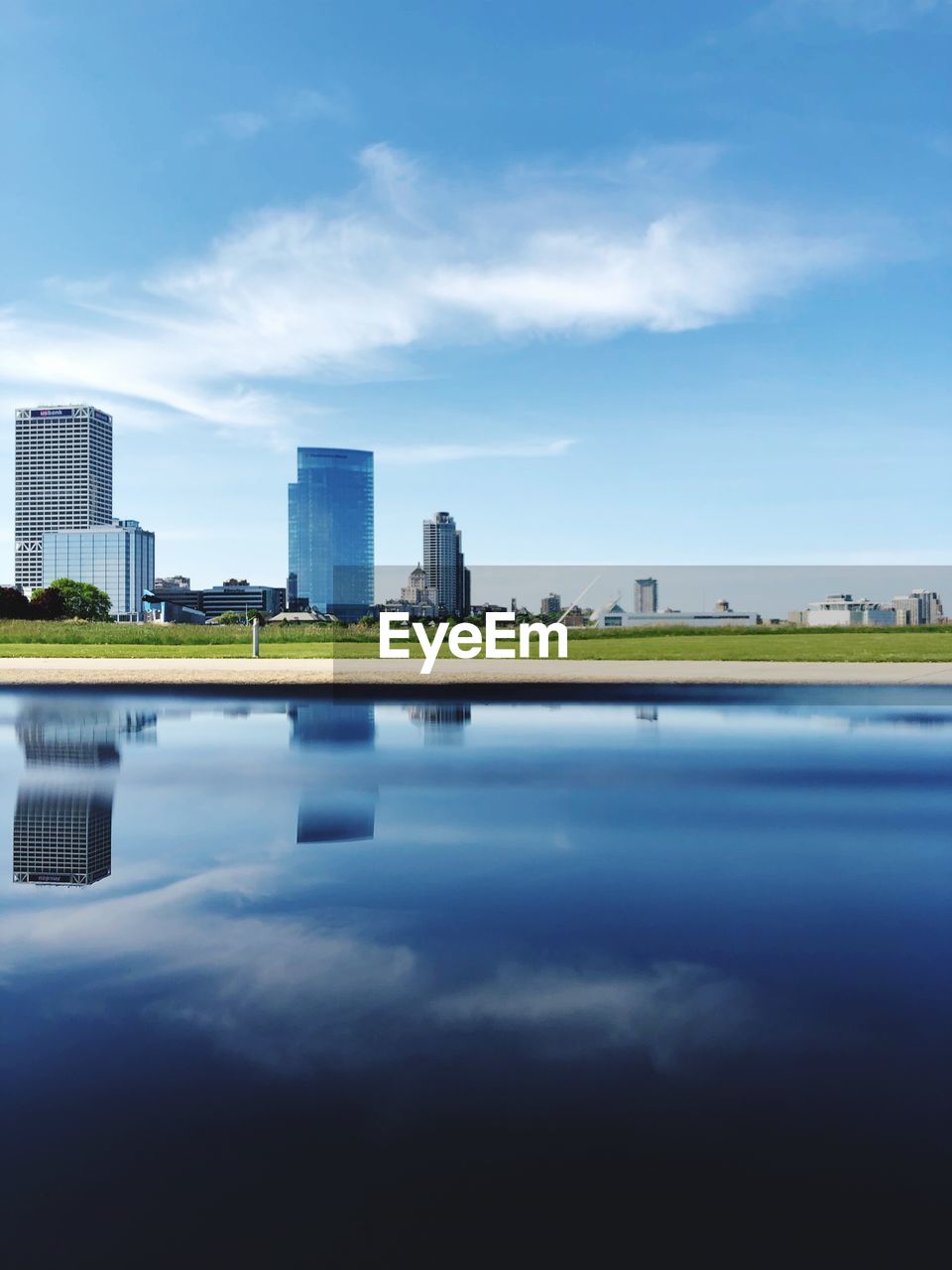 Reflection of buildings in city against sky