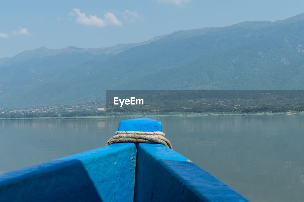 BOAT IN LAKE AGAINST MOUNTAINS
