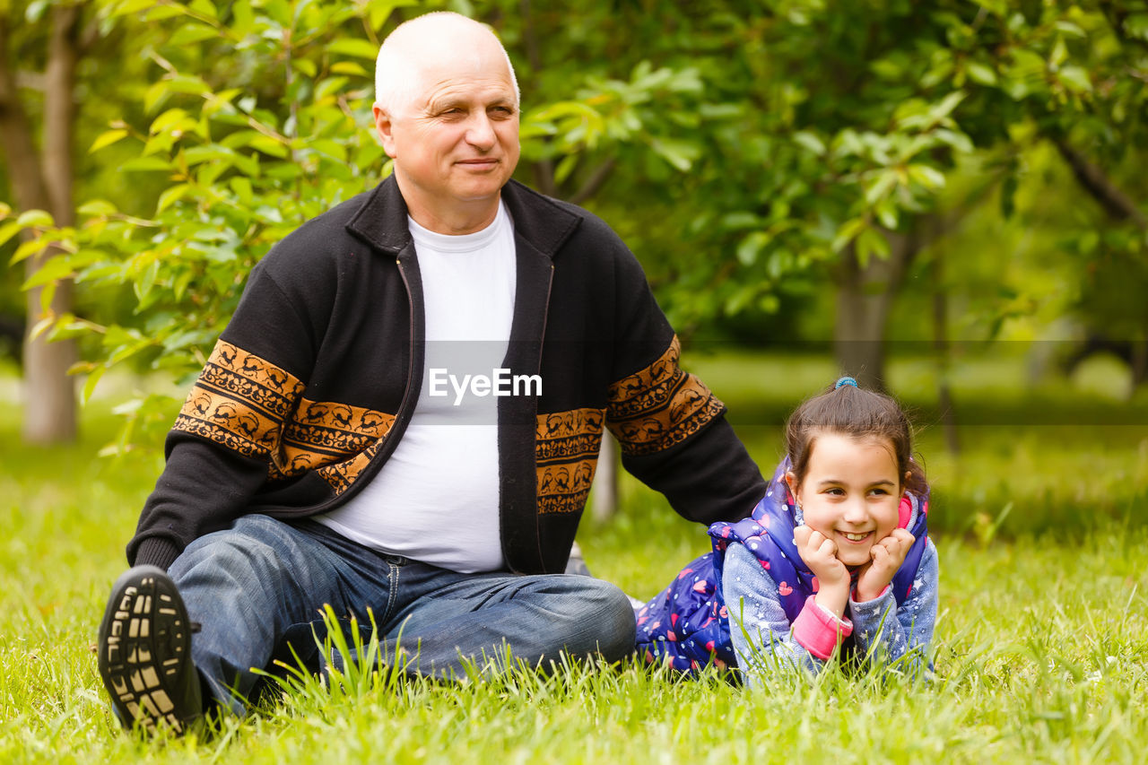 PORTRAIT OF SMILING SIBLINGS STANDING ON GRASS