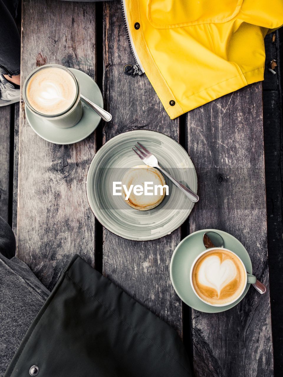 High angle view of coffee cups with cookies served on wooden table