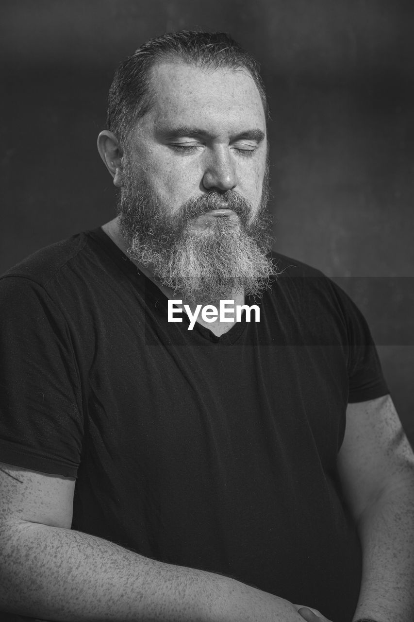 adult, one person, men, facial hair, beard, human hair, person, portrait, mature adult, black, black and white, human face, casual clothing, waist up, senior adult, gray hair, monochrome, lifestyles, arm, indoors, serious, front view, monochrome photography, hairstyle, studio shot, contemplation, looking, emotion, t-shirt