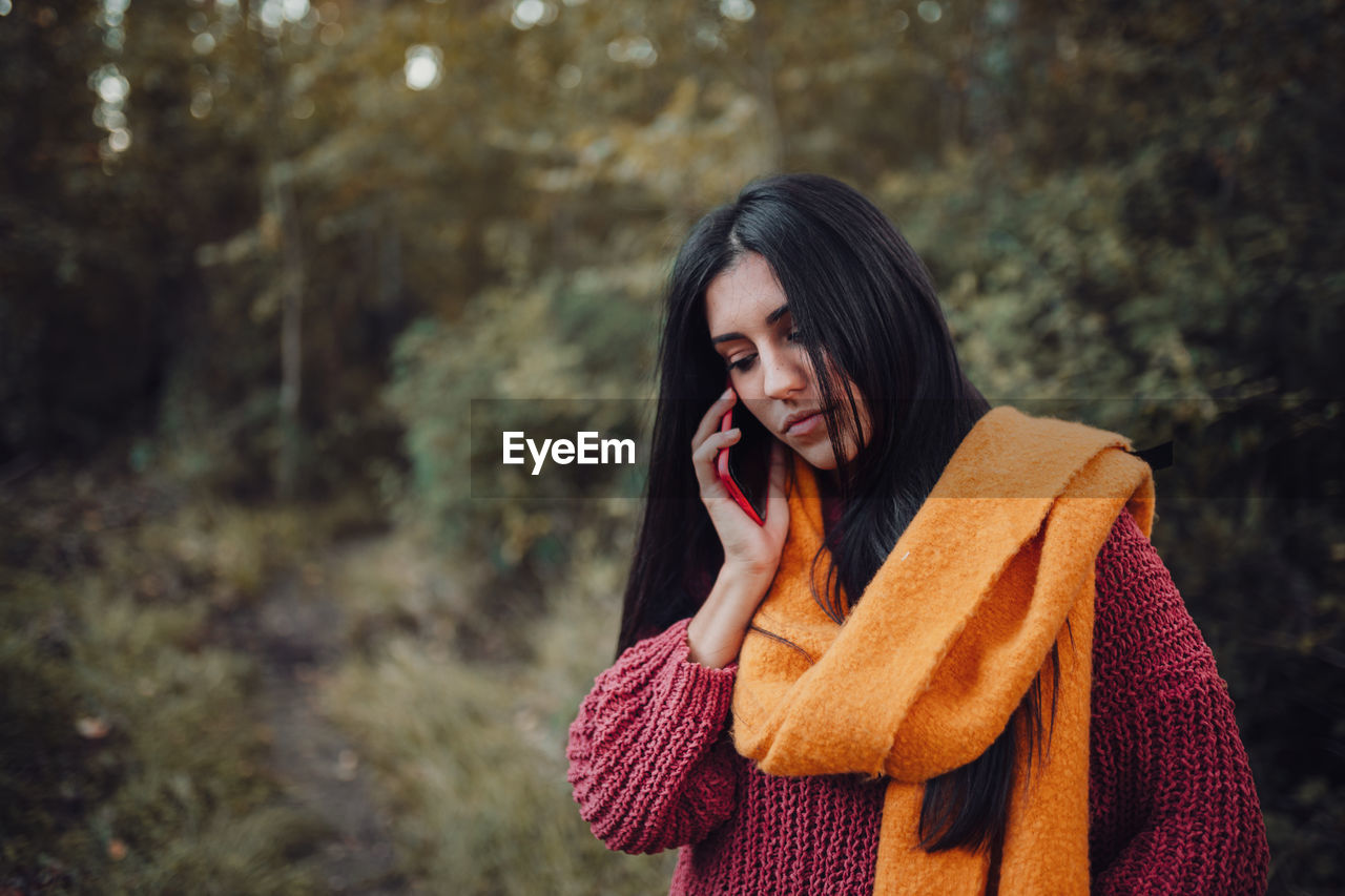 Close-up of young woman using smart phone in forest