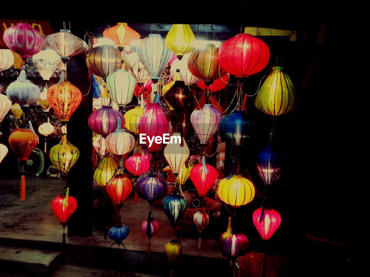 CLOSE-UP OF ILLUMINATED LANTERNS HANGING ON CLOTHESLINE