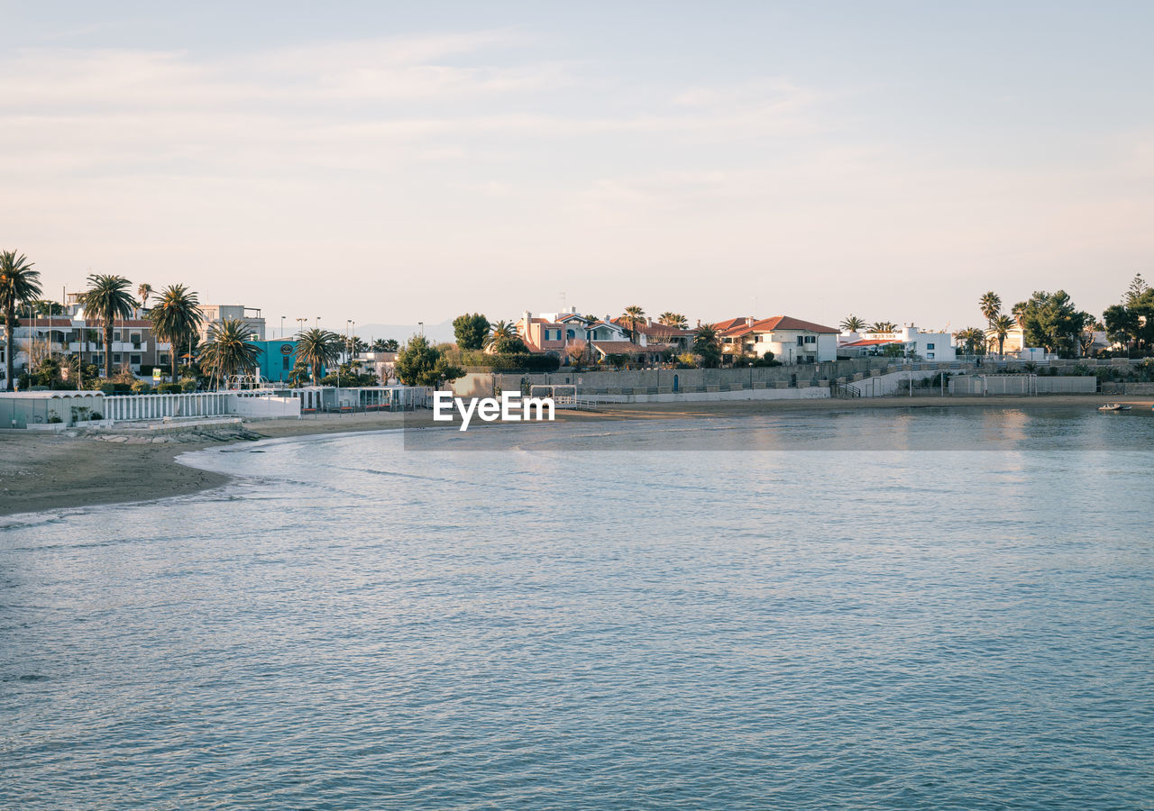 SEA BY TOWNSCAPE AGAINST SKY