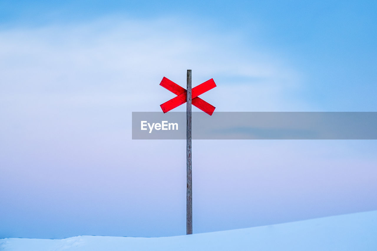 Low angle view of  sign in snow against sky