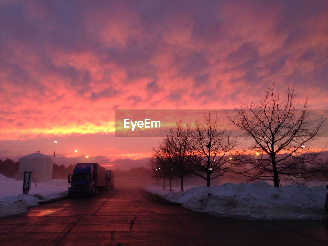 Road against cloudy sky in winter during sunset