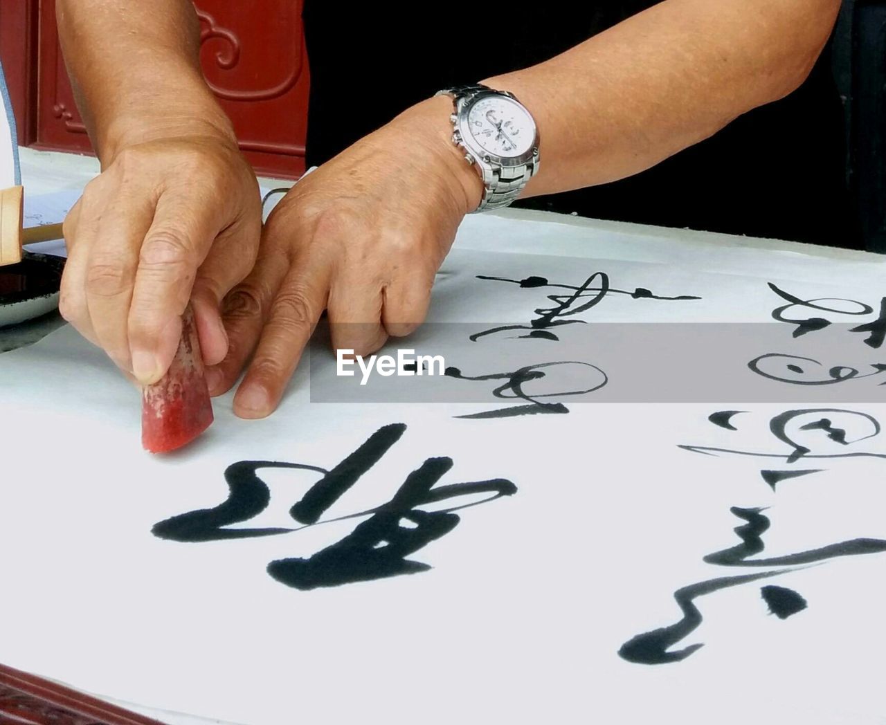 Close-up of hands writing chinese calligraphy