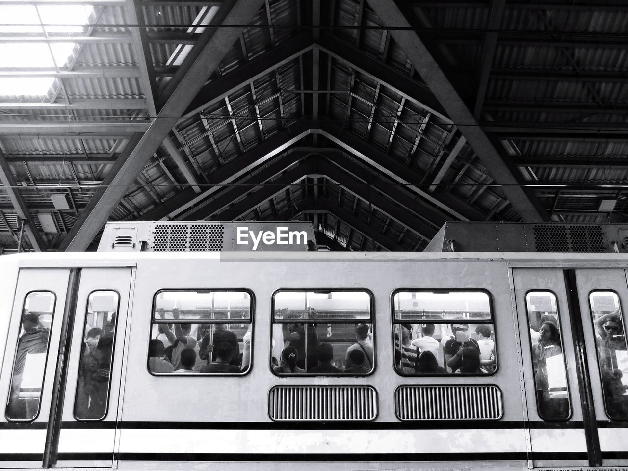 Low angle view of people traveling in train at station