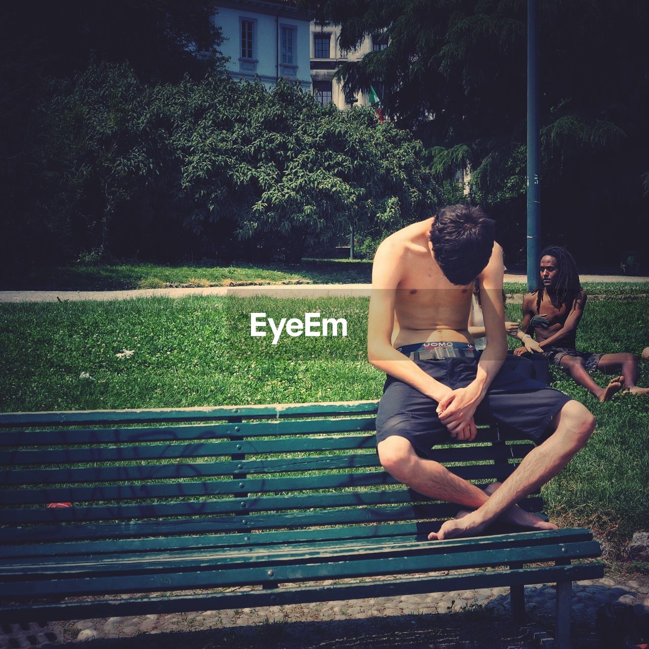 WOMAN SITTING ON BENCH IN PARK