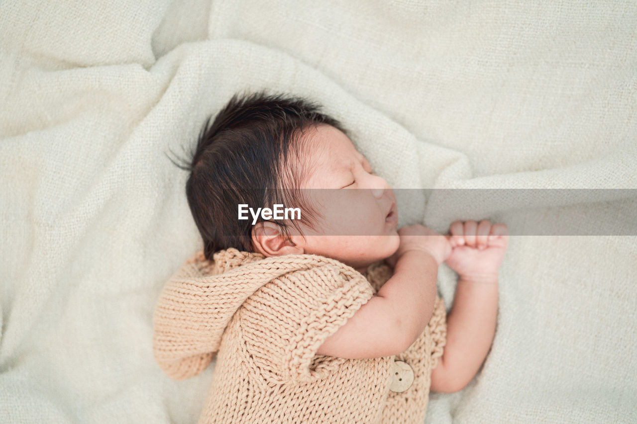 High angle view of baby sleeping on bed