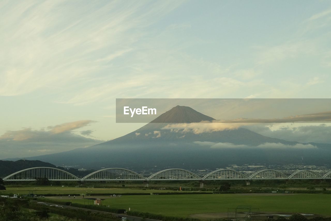 View of bridge over mountain against cloudy sky