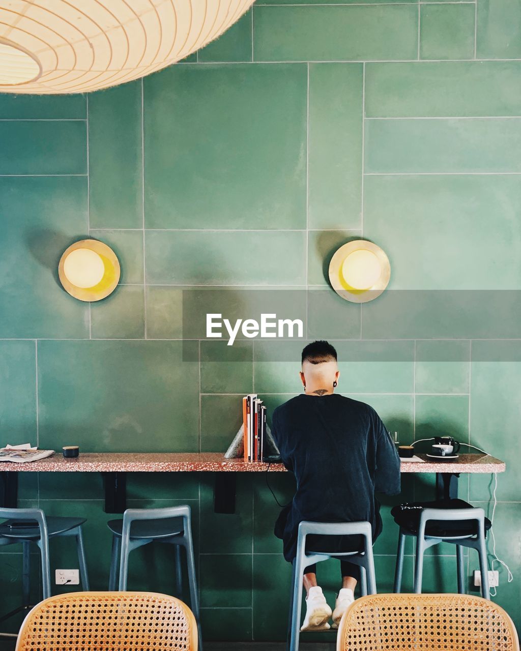 MAN AND WOMAN STANDING ON TABLE BY CHAIRS