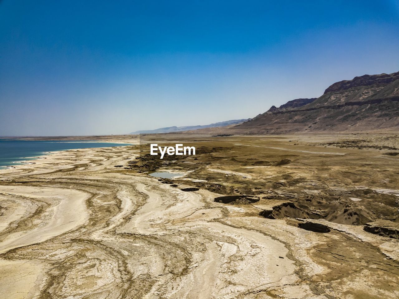 Scenic view of beach against clear blue sky