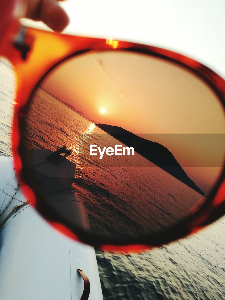 Silhouette mountain seen through sunglasses during sunset