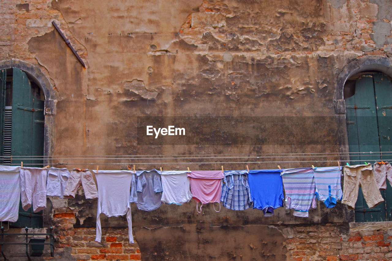 Clothes drying on clothesline against old house