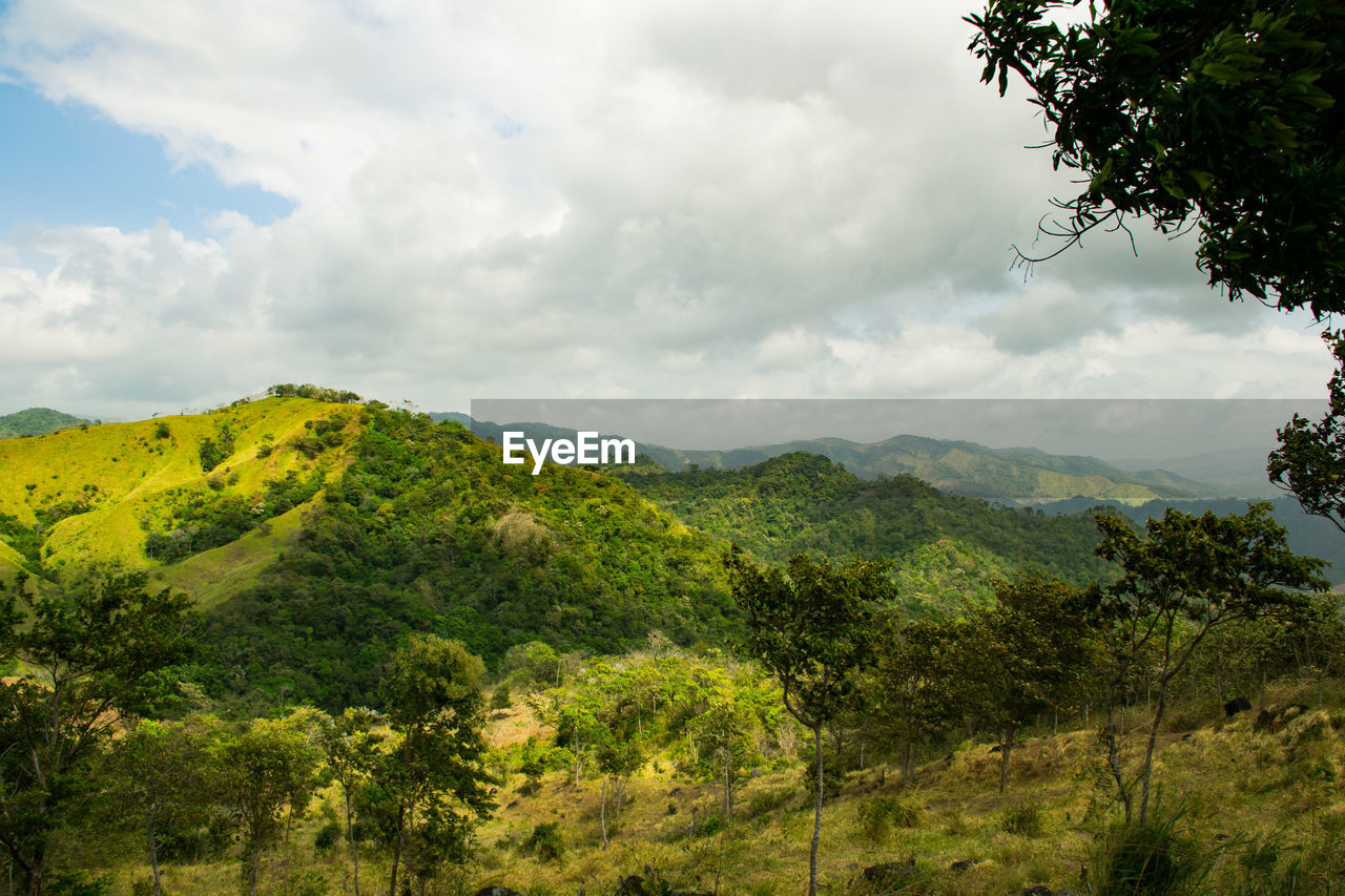 SCENIC VIEW OF MOUNTAINS AGAINST CLOUDY SKY