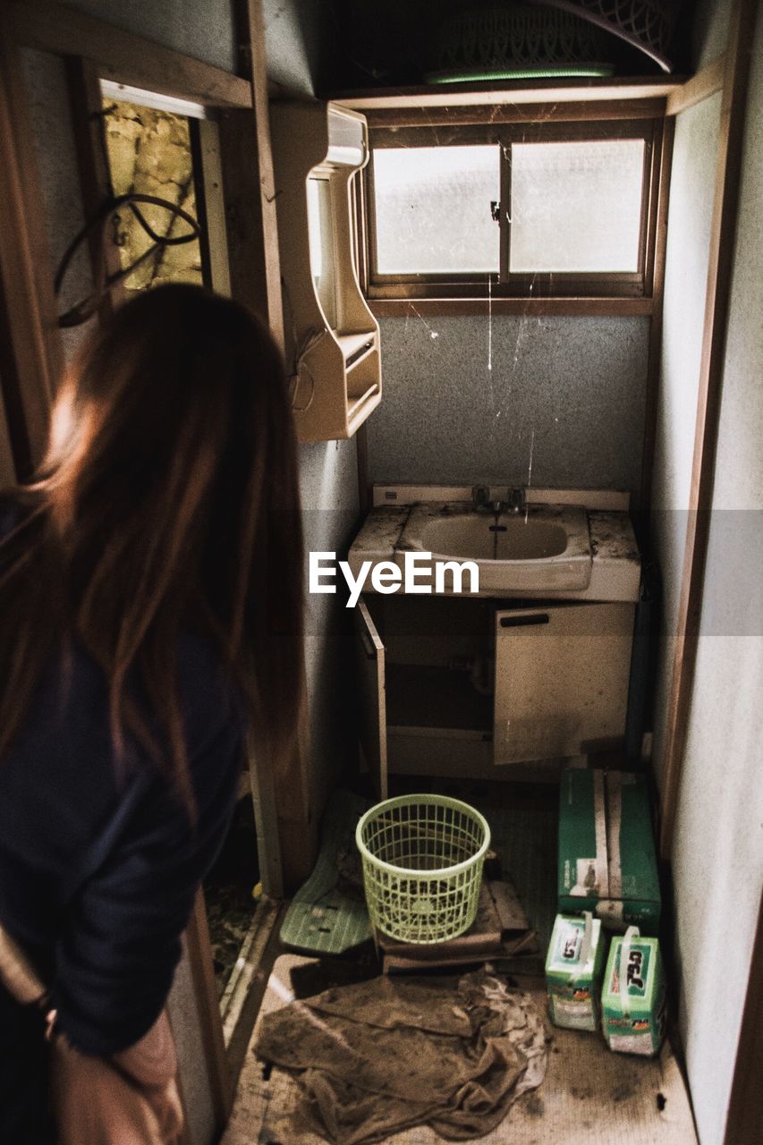 Woman peeping in abandoned house