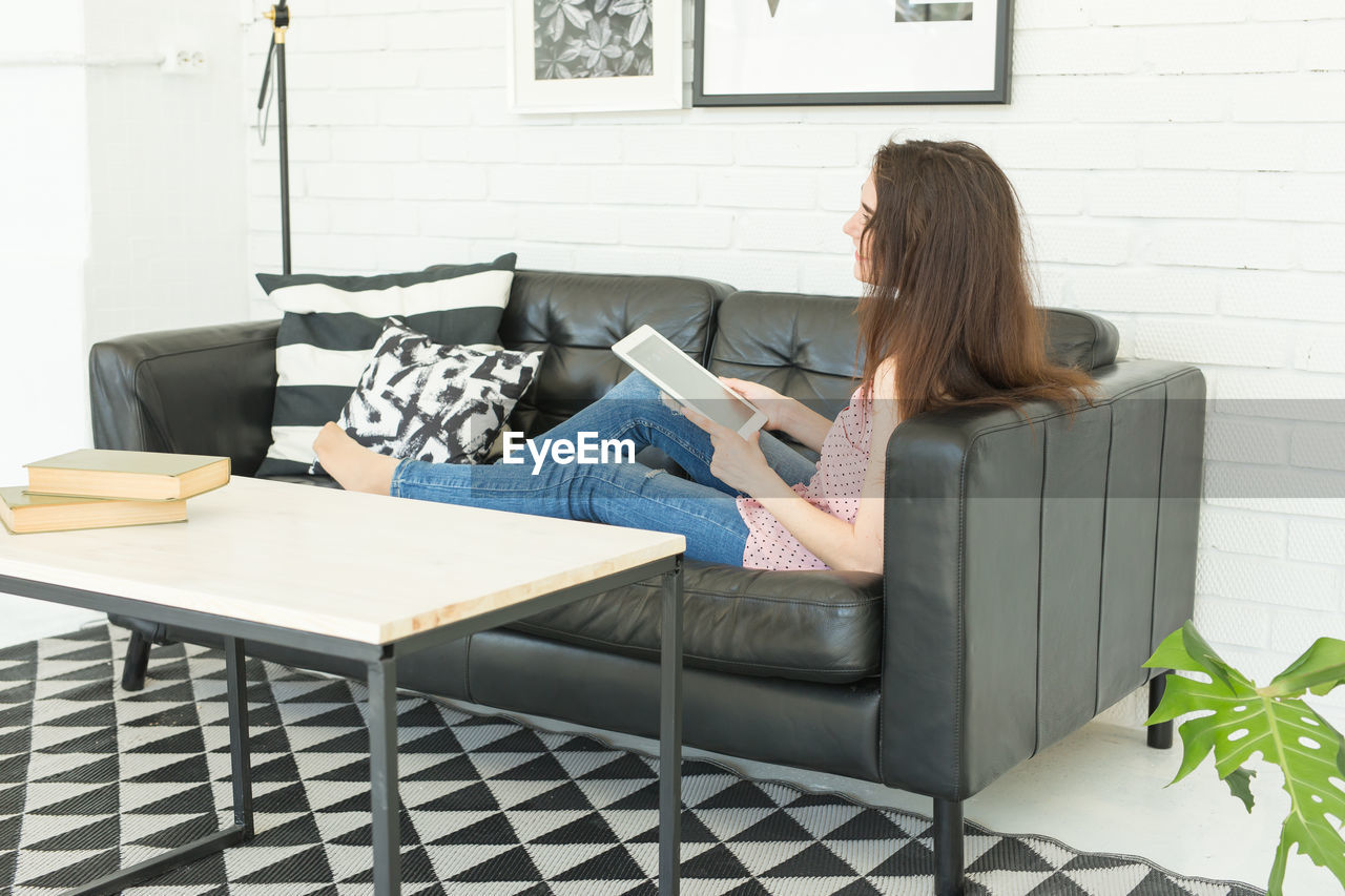 WOMAN SITTING ON SOFA IN SHELF