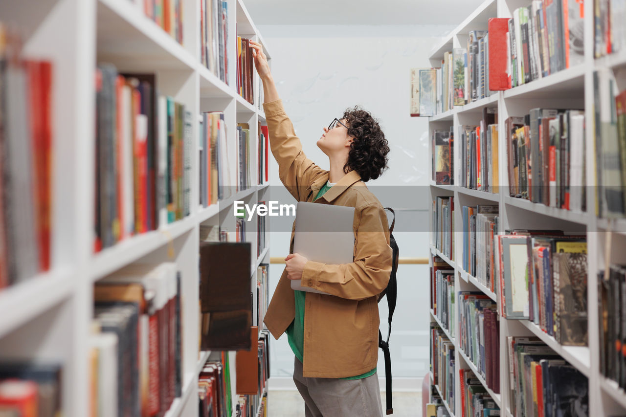 portrait of smiling woman standing in library