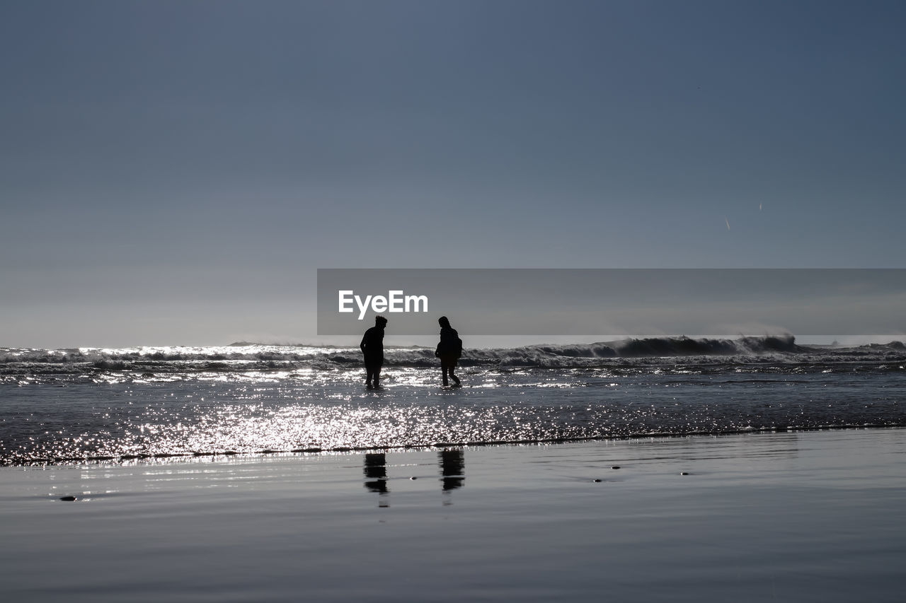 SILHOUETTE PEOPLE ON BEACH AGAINST SKY DURING SUNSET