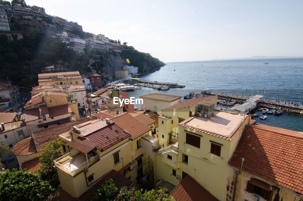 High angle view of houses by sea against sky