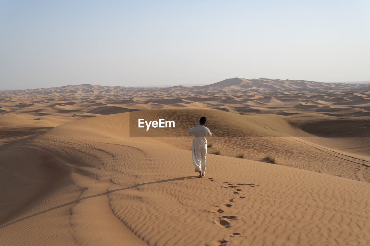 Rear view of man on sand dune