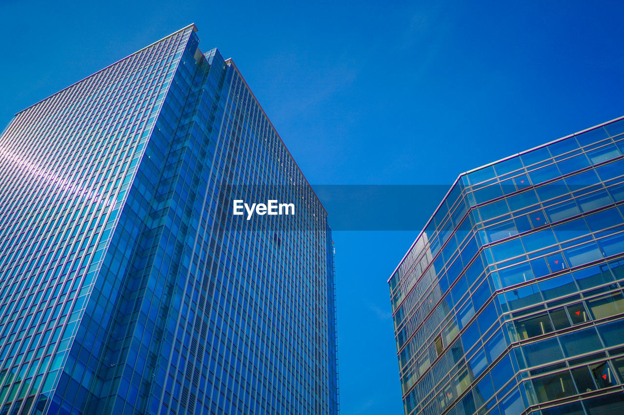 low angle view of skyscraper against blue sky