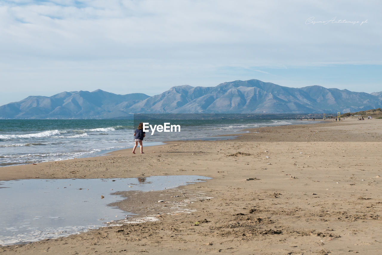 Rear view of girl on shore at beach