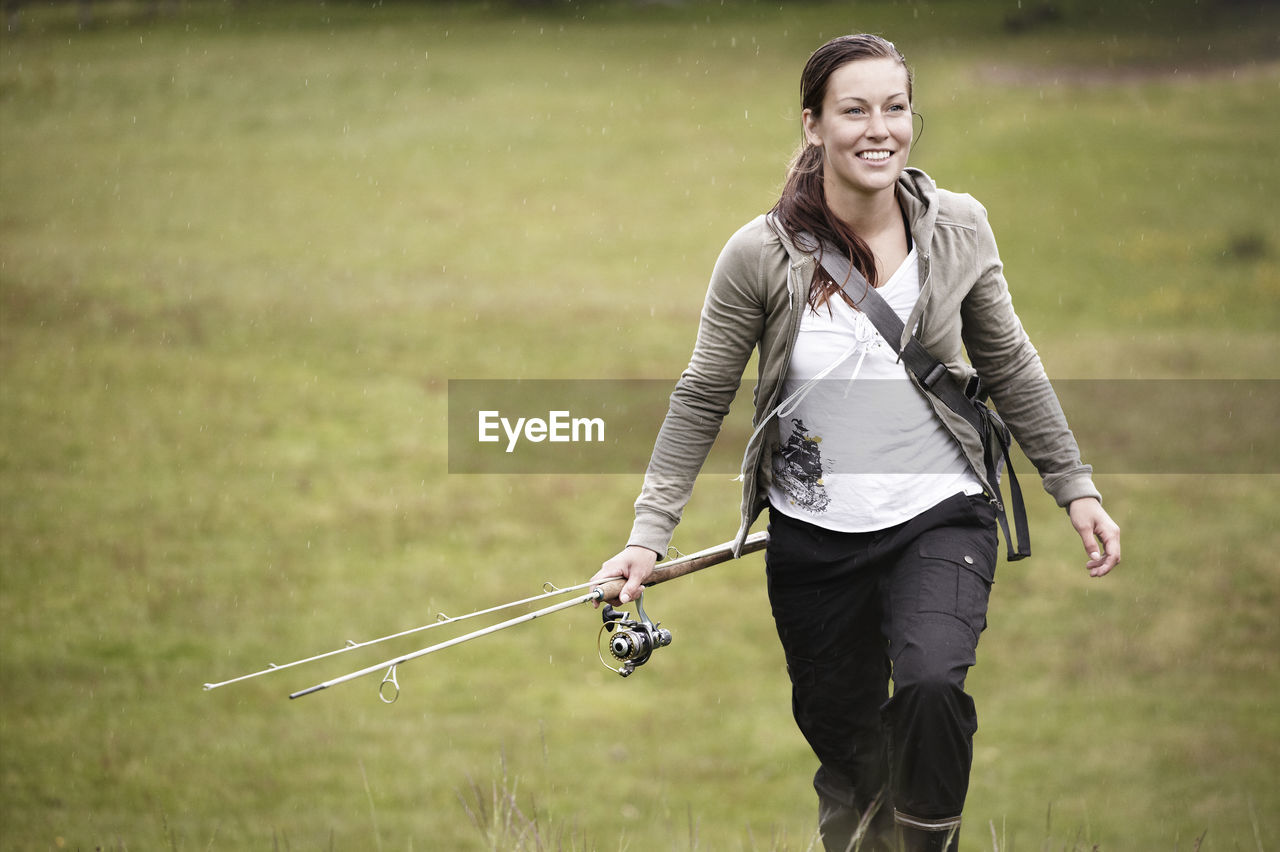 Young woman walking with casting rod