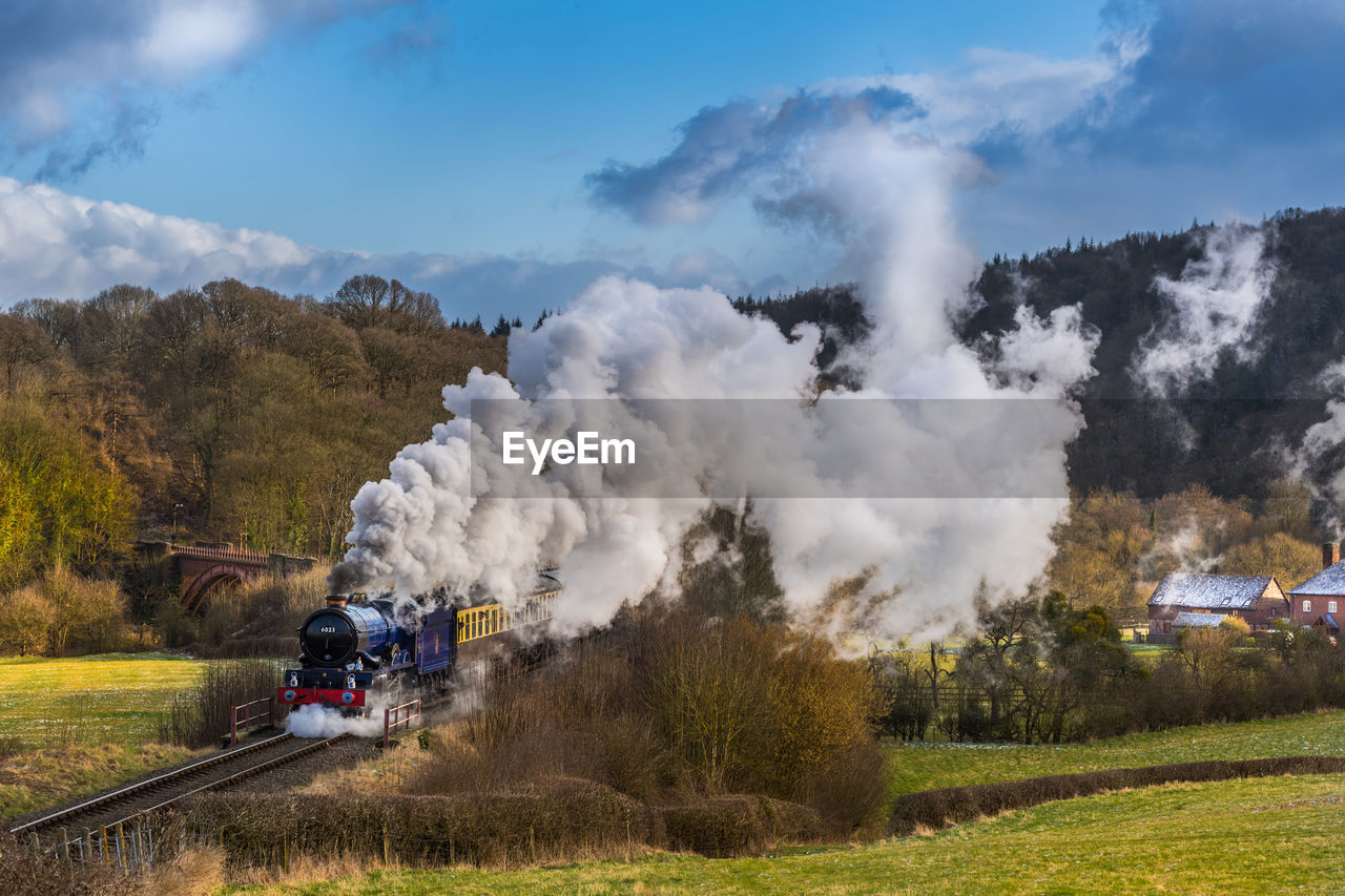High angle view of steam train moving amidst landscape against sky