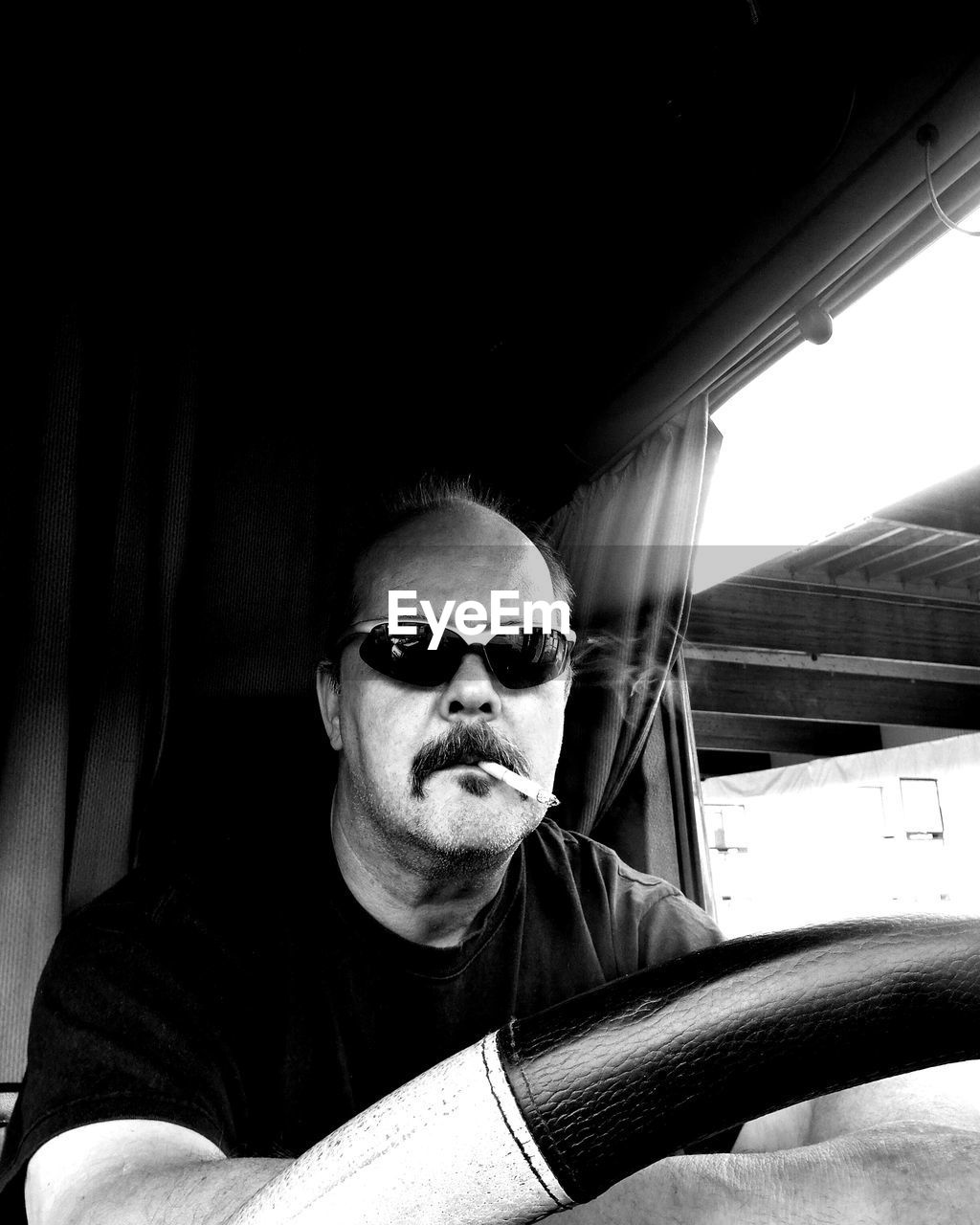 Portrait of man wearing sunglasses while driving car