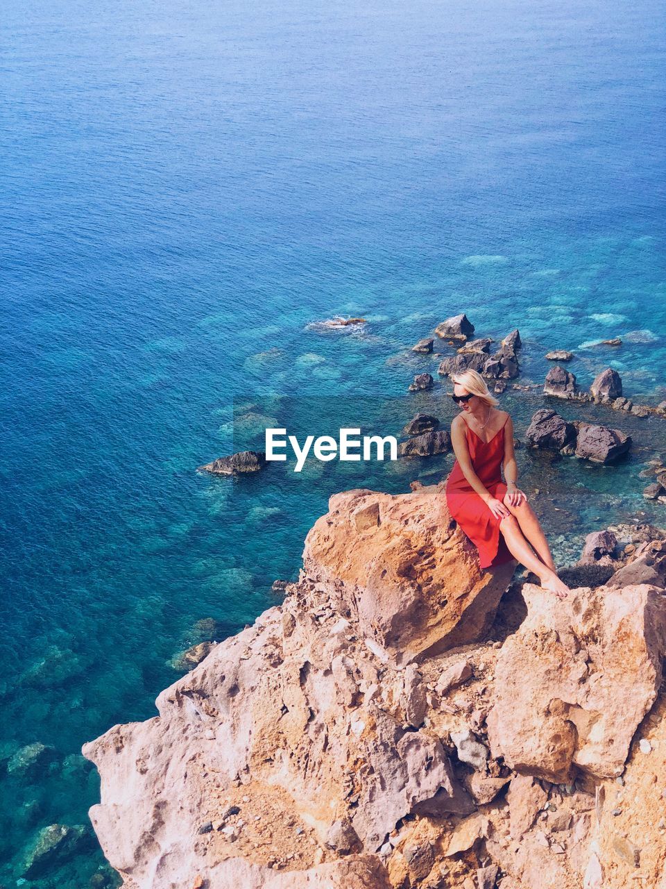 High angle view of women standing on rock by sea