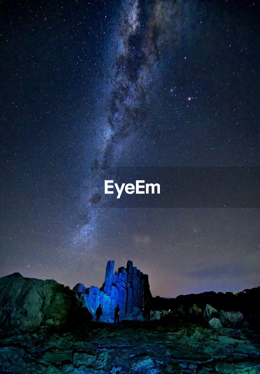 Scenic view of rock formations against star field