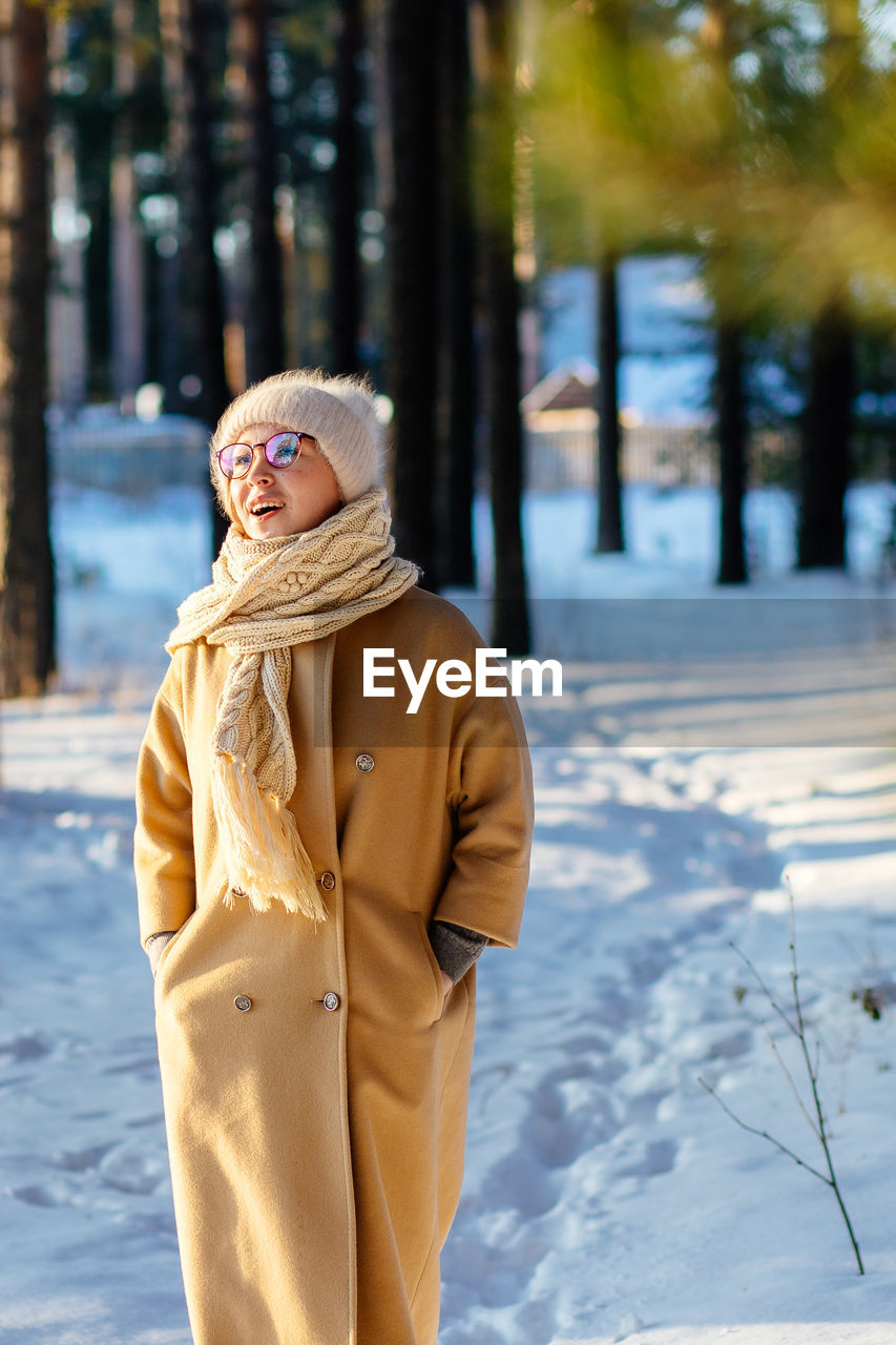 Woman standing on snow covered tree