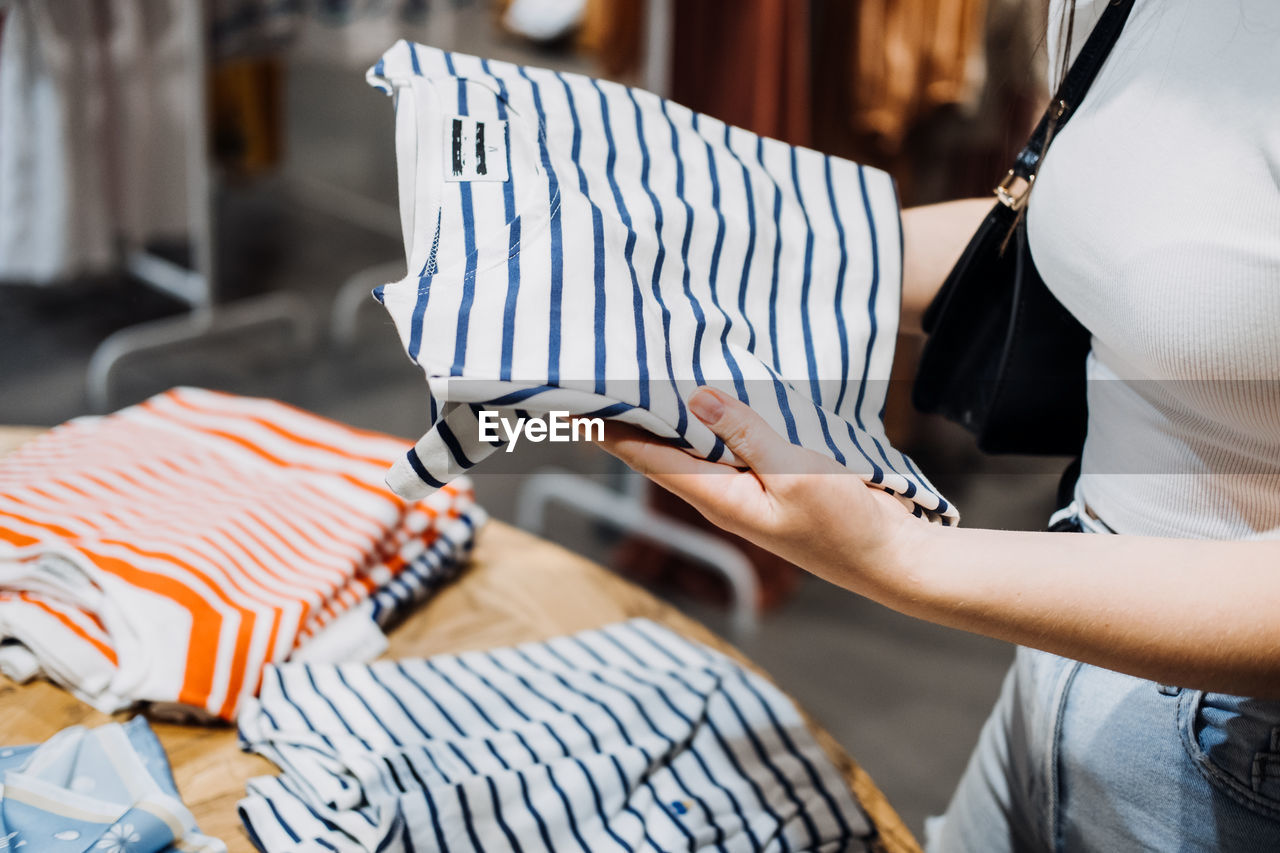 Modern latina young woman choosing 100 percent organic cotton wear t shirt in modern eco-friendly