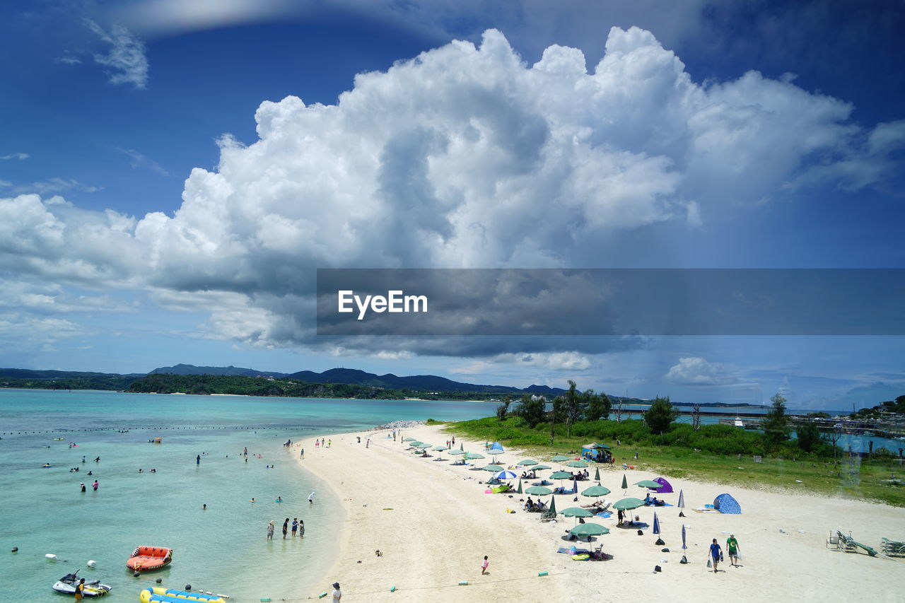 Group of people on beach against sky