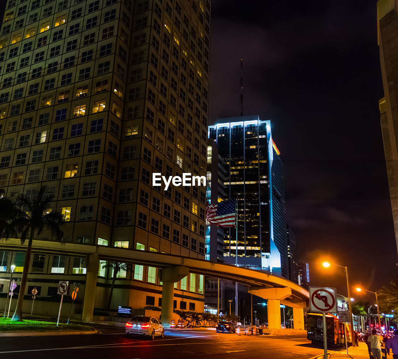 ILLUMINATED STREET BY BUILDINGS AT NIGHT