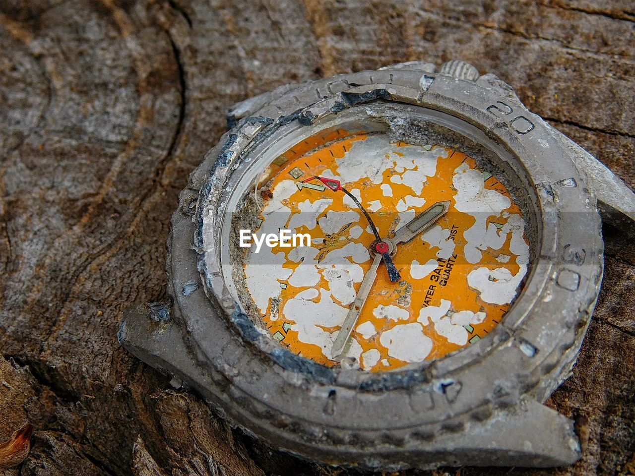 Close-up of weathered wristwatch on wood