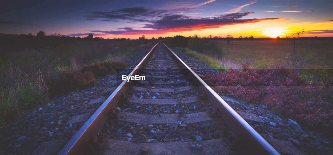 VIEW OF RAILROAD TRACKS AT SUNSET