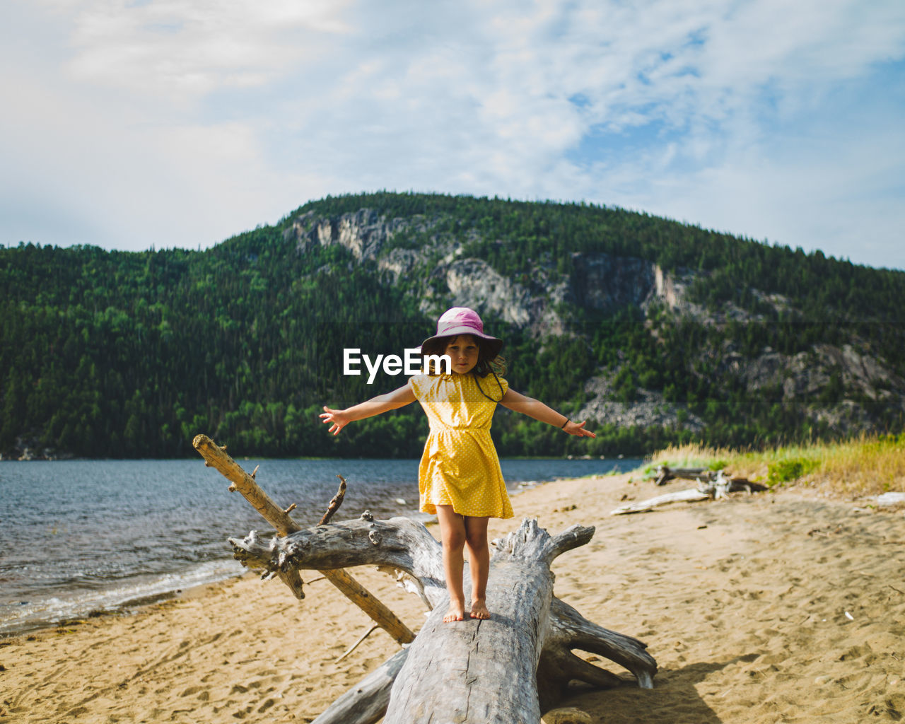 Full length of girl standing at beach against sky