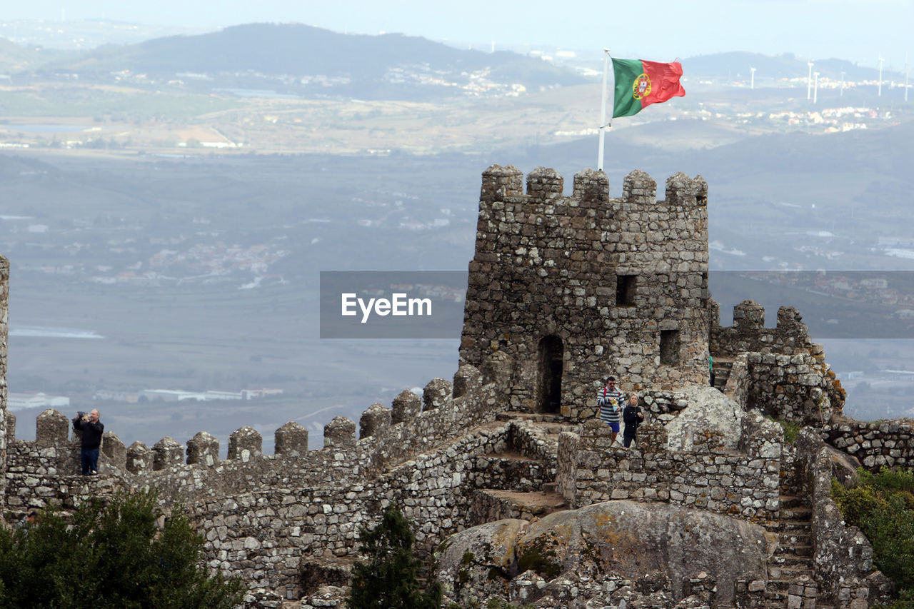 Flags flies on a tower of the castle of the moors in sintra. panoramic view of flag against sky. 