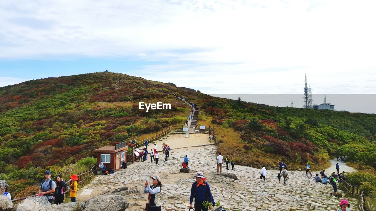 People on mountain against sky