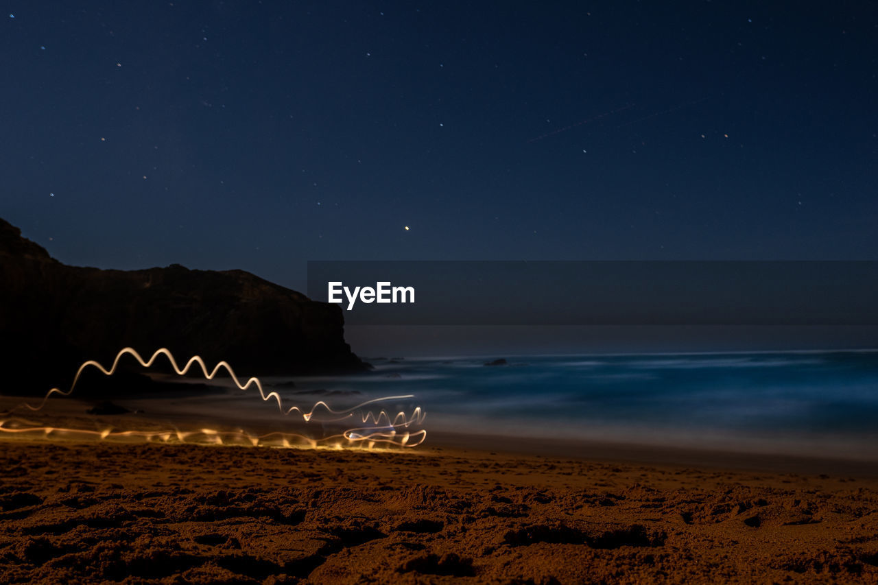 Scenic view of beach against sky at night