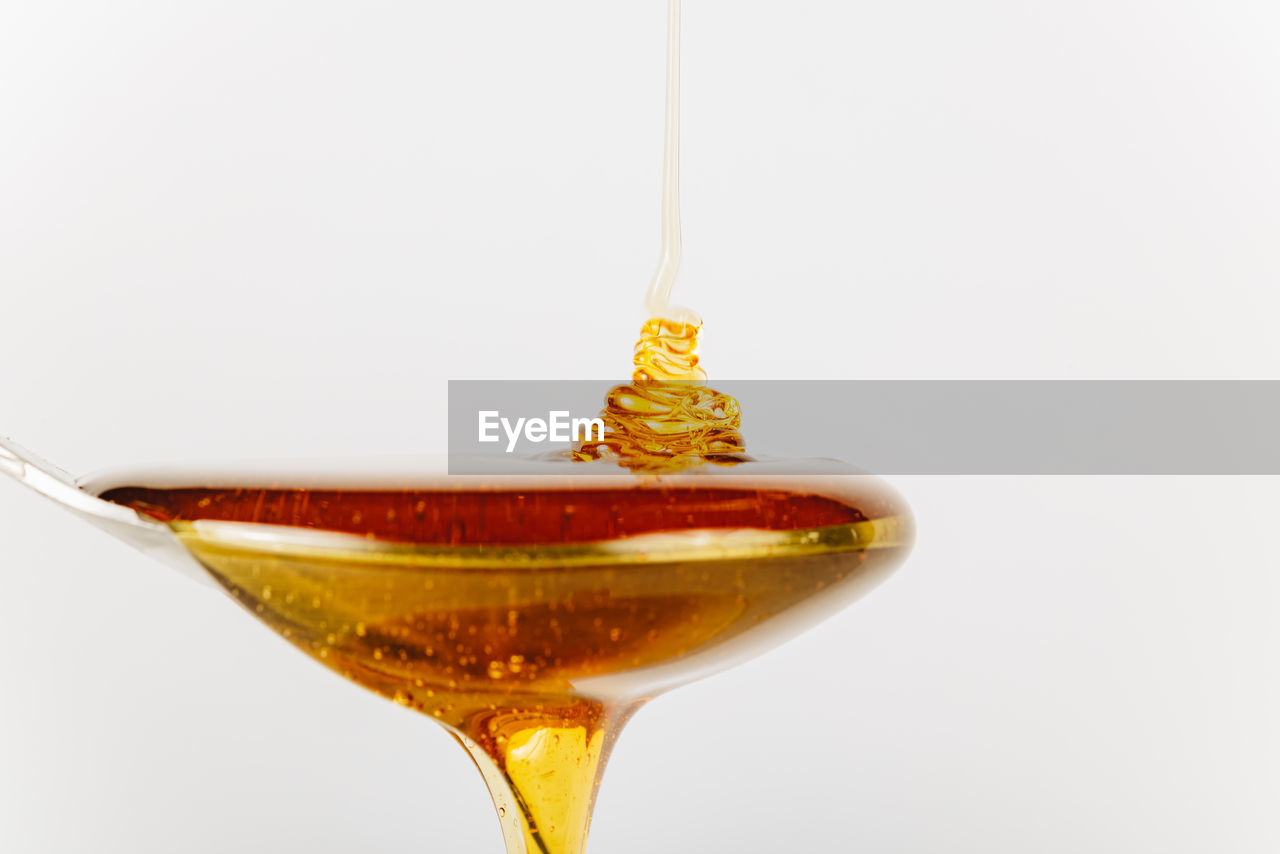 food and drink, drink, refreshment, alcohol, studio shot, alcoholic beverage, cocktail, distilled beverage, glass, food, white background, pouring, indoors, no people, martini, gold, cut out, martini glass, single object, close-up, household equipment