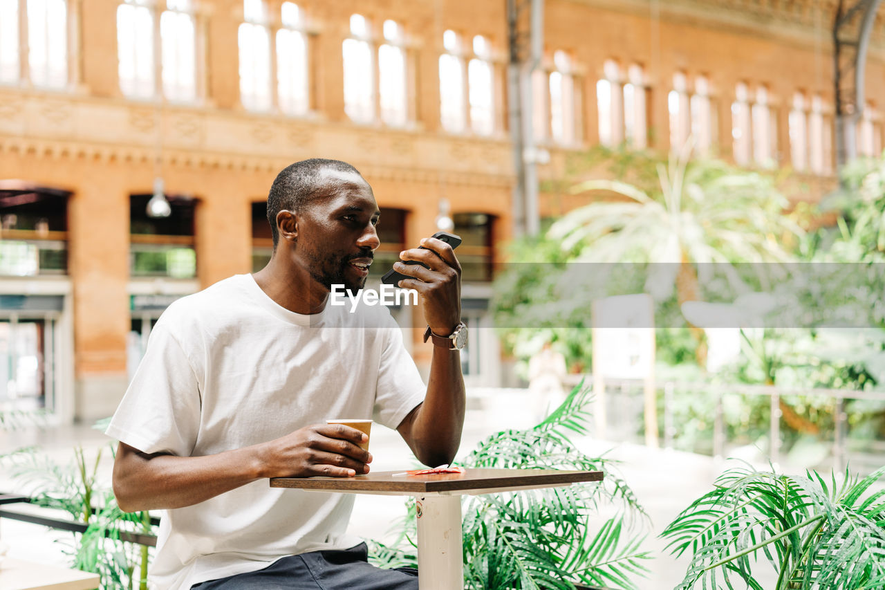 Man talking on phone while sitting at cafe